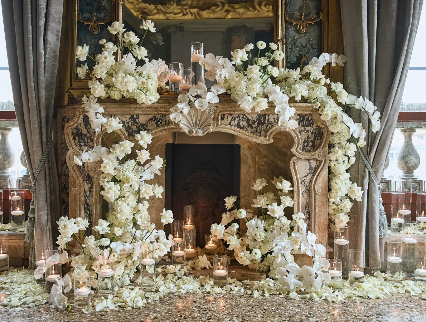 Marble fireplace decorated with white orchids, roses and candles for a ceremony in a Venice palace