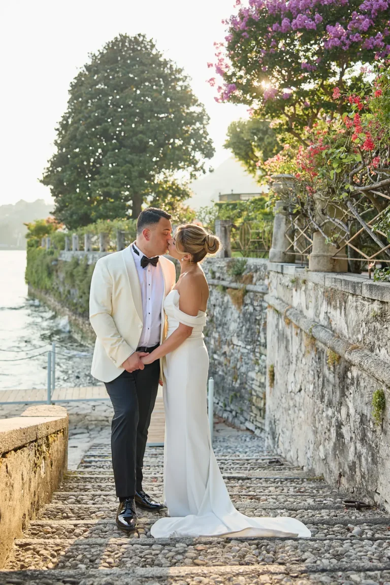 Melissa and Eric kissing on the stone steps down to the lake at Villa Pizzo